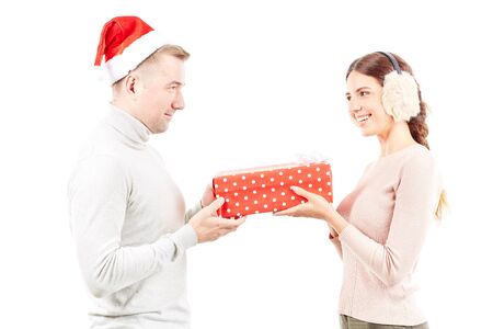 Studio portrait of man and woman with Christmas present on white backgroundの写真素材