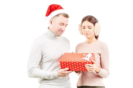 Studio portrait of man and woman with Christmas present on white backgroundの写真素材