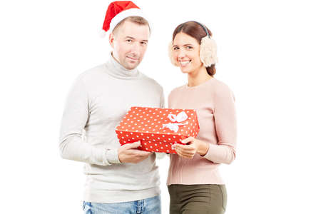 Studio portrait of man and woman with Christmas present on white backgroundの写真素材