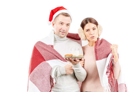 Portrait of couple wrapped in blanket, man wearing Santa hatの写真素材