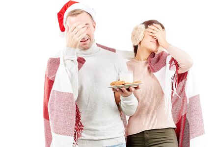 Portrait of couple wrapped in blanket, man wearing Santa hatの写真素材