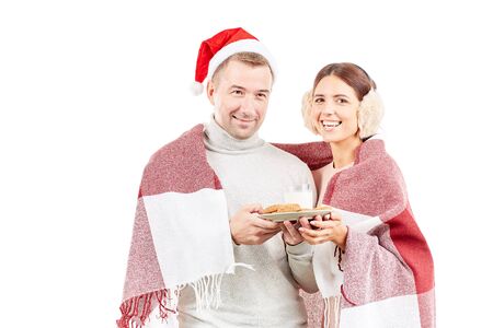 Portrait of couple wrapped in blanket, man wearing Santa hatの写真素材