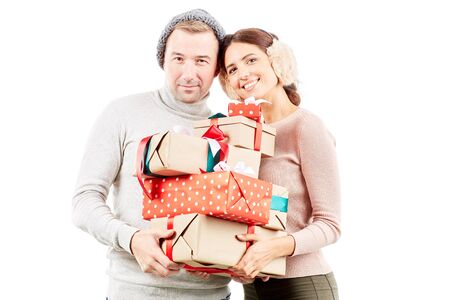 Portrait of beautiful couple holding heap of Christmas giftsの写真素材