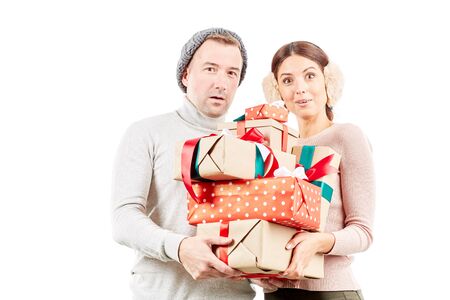 Portrait of beautiful couple holding heap of Christmas giftsの写真素材