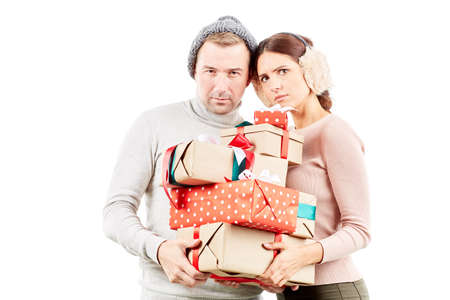 Portrait of beautiful couple holding heap of Christmas giftsの写真素材