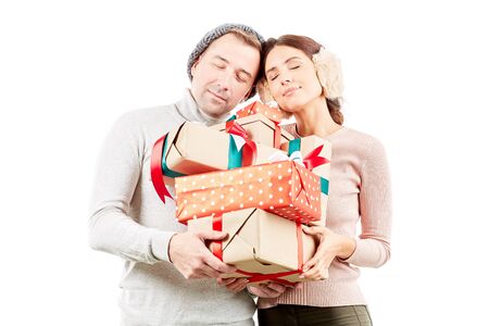 Portrait of beautiful couple holding heap of Christmas giftsの写真素材