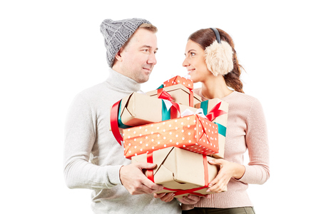 Portrait of beautiful couple holding heap of Christmas giftsの写真素材