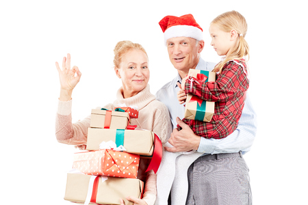 Christmas portrait of grandparents and granddaughter posing with giftsの写真素材