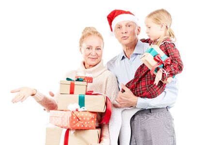 Christmas portrait of grandparents and granddaughter posing with giftsの写真素材