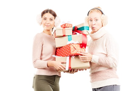 Portrait of senior mother and adult daughter exchanging Christmas giftsの写真素材