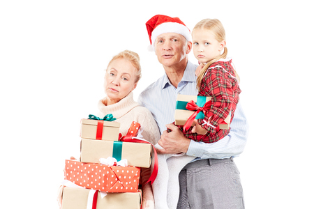 Christmas portrait of grandparents and granddaughter posing with giftsの写真素材