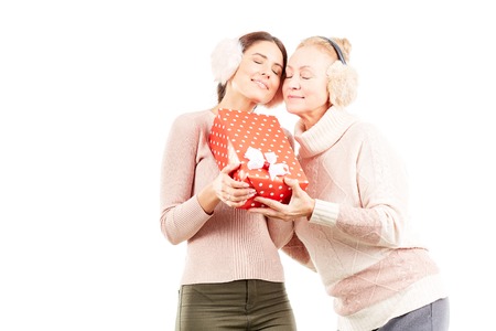 Portrait of senior mother and adult daughter exchanging Christmas giftsの写真素材