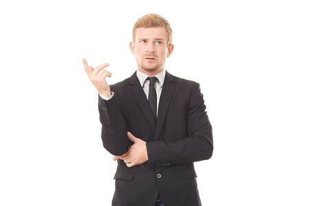 Portrait of pensive young businessman in black suit on white backgroundの写真素材