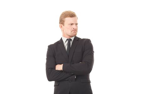 Portrait of displeased businessman in black suit on white backgroundの写真素材