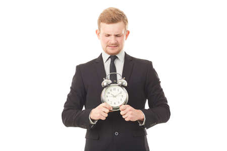 Portrait of young businessman with alarm clock on white backgroundの写真素材