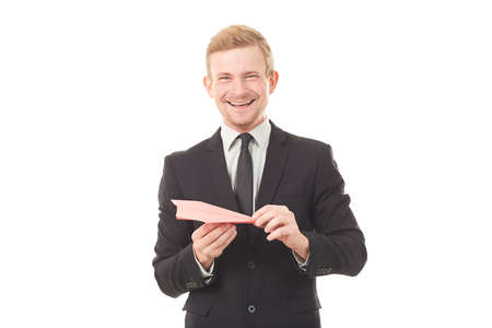 Portrait of businessman holding paper plane on white backgroundの写真素材