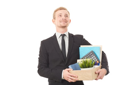 Portrait of young man holding box with personal belongings on white backgroundの写真素材