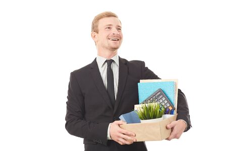 Portrait of young man holding box with personal belongings on white backgroundの写真素材