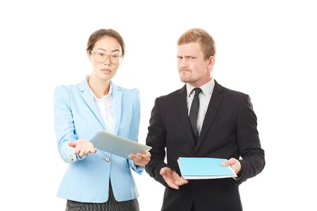 Portrait of Asian businesswoman and Caucasian businessman holding tablet computer and documentsの写真素材