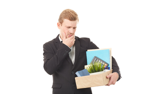 Portrait of young man holding box with personal belongings on white backgroundの写真素材
