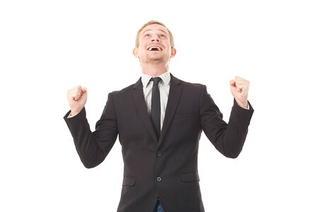 Portrait of ecstatic young businessman in black suit on white backgroundの写真素材