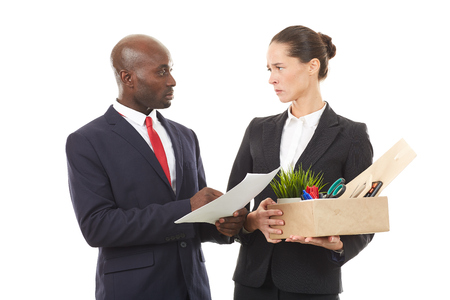 Portrait of male employer and female employee holding box with personal belongingsの写真素材