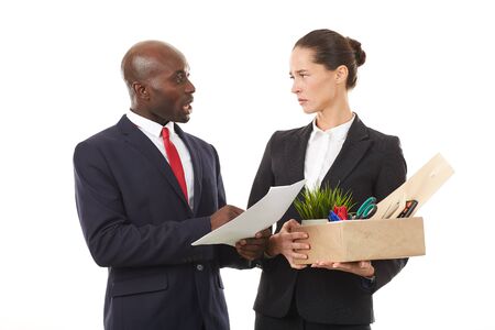 Portrait of male employer and female employee holding box with personal belongingsの写真素材
