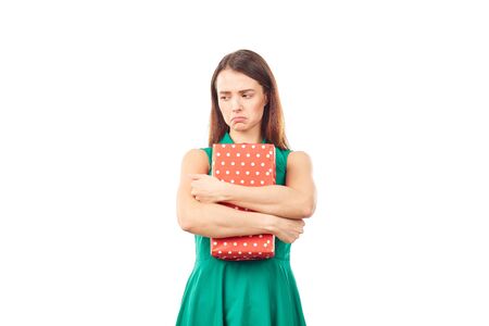 Portrait of young woman holding gift box wrapped in red paperの写真素材
