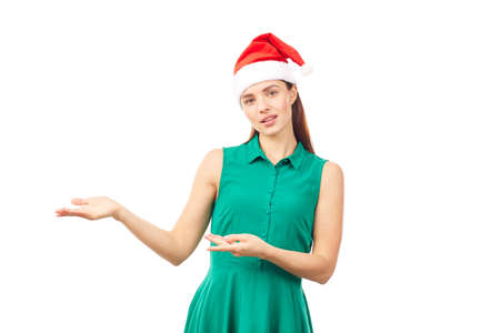 Young woman wearing emerald green dress and Santa hat on white backgroundの写真素材