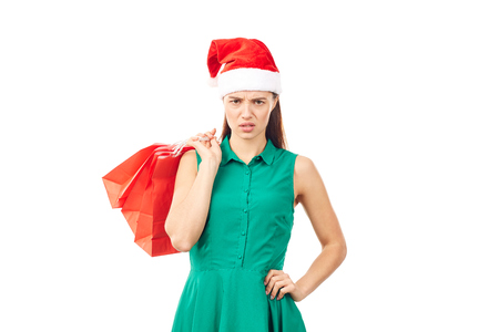 Studio portrait of young woman in Santa hat posing with shopping bags on white backgroundの写真素材
