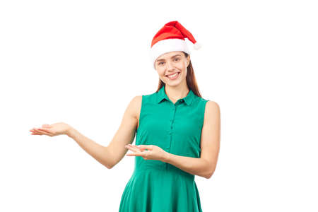 Young woman wearing emerald green dress and Santa hat on white backgroundの写真素材