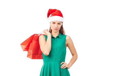 Studio portrait of young woman in Santa hat posing with shopping bags on white backgroundの写真素材
