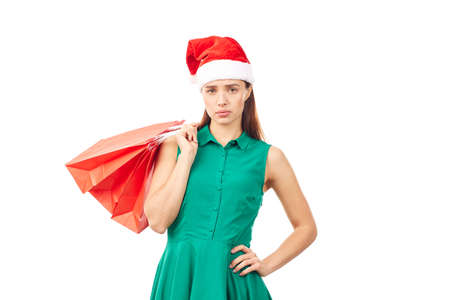 Studio portrait of young woman in Santa hat posing with shopping bags on white backgroundの写真素材