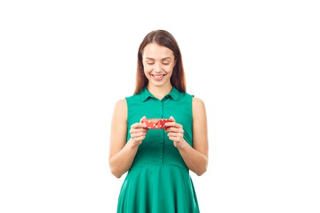 Studio portrait of beautiful young woman holding small gift box on white backgroundの写真素材