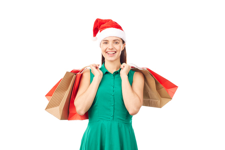 Studio portrait of young woman in Santa hat posing with shopping bags on white backgroundの写真素材