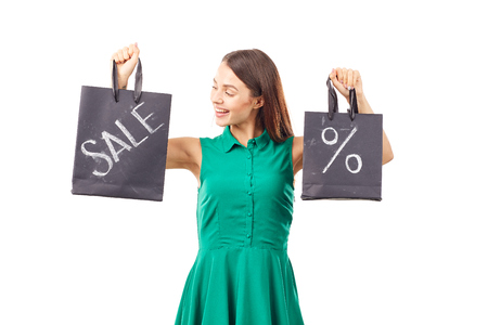 Portrait of female shopaholic holding shopping bags with sale/discount signの写真素材