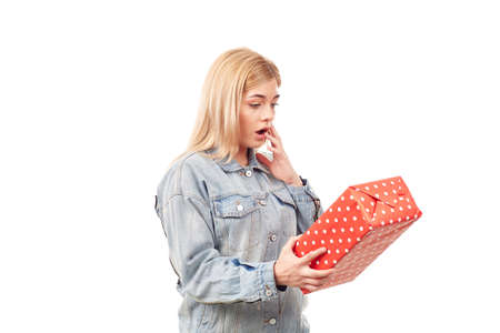 Young blonde in denim jacket holding gift boxの写真素材