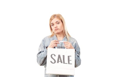 Beautiful blonde woman holding shopping bag with sale signの写真素材