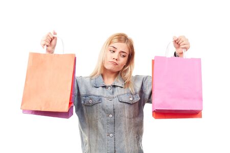Portrait of young blonde woman holding shopping bags in both handsの写真素材