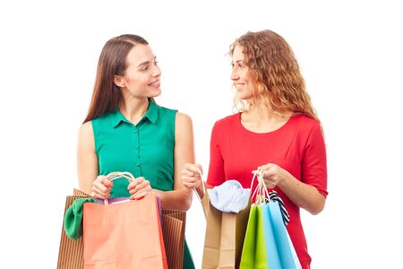Portrait of two female friends holding multi-colored shopping bagsの写真素材