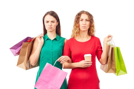 Portrait of two female friends holding multi-colored shopping bagsの写真素材