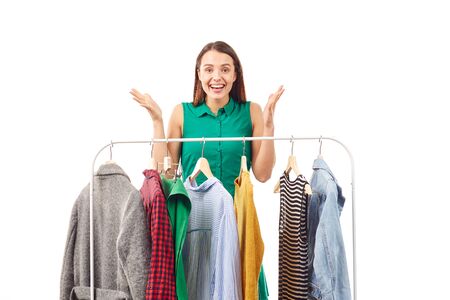 Young woman choosing clothes on rack on white backgroundの写真素材