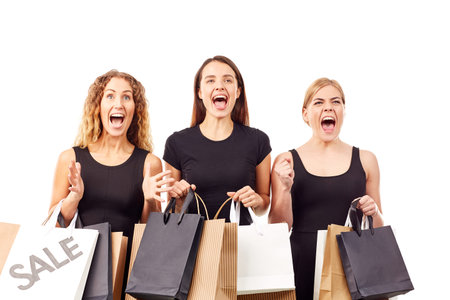 Portrait of three young women in black holding many shopping bags