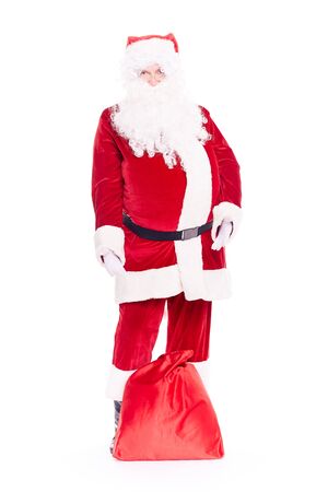 Portrait of Christmas character Santa Claus in traditional costume with red sack on white backgroundの写真素材