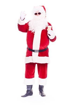 Portrait of cool Santa Claus in traditional costume wearing sunglasses on white backgroundの写真素材