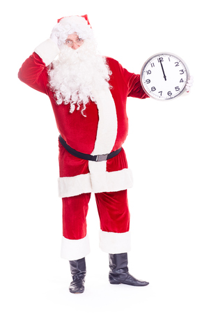 Portrait of Santa Claus in traditional costume holding clocks showing midnightの写真素材