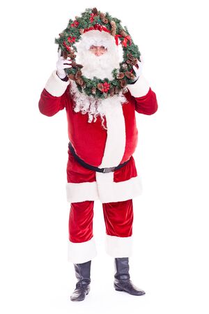 Portrait of Santa Claus in traditional costume holding Christmas wreathの写真素材