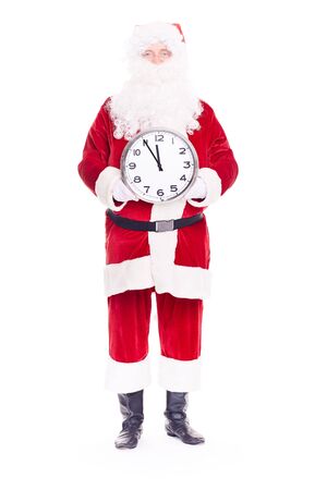 Portrait of Santa Claus in traditional costume holding clock showing five minutes to twelveの写真素材