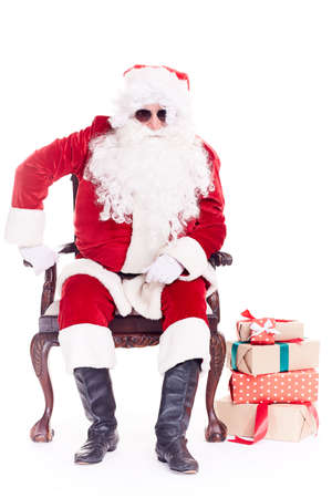 Portrait of swaggy Santa Claus in sunglasses relaxing in chair on white backgroundの写真素材