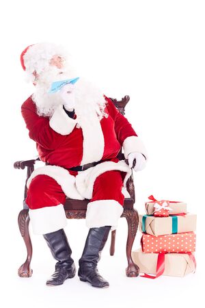 Portrait of Santa Claus sitting in chair and launching paper airplaneの写真素材